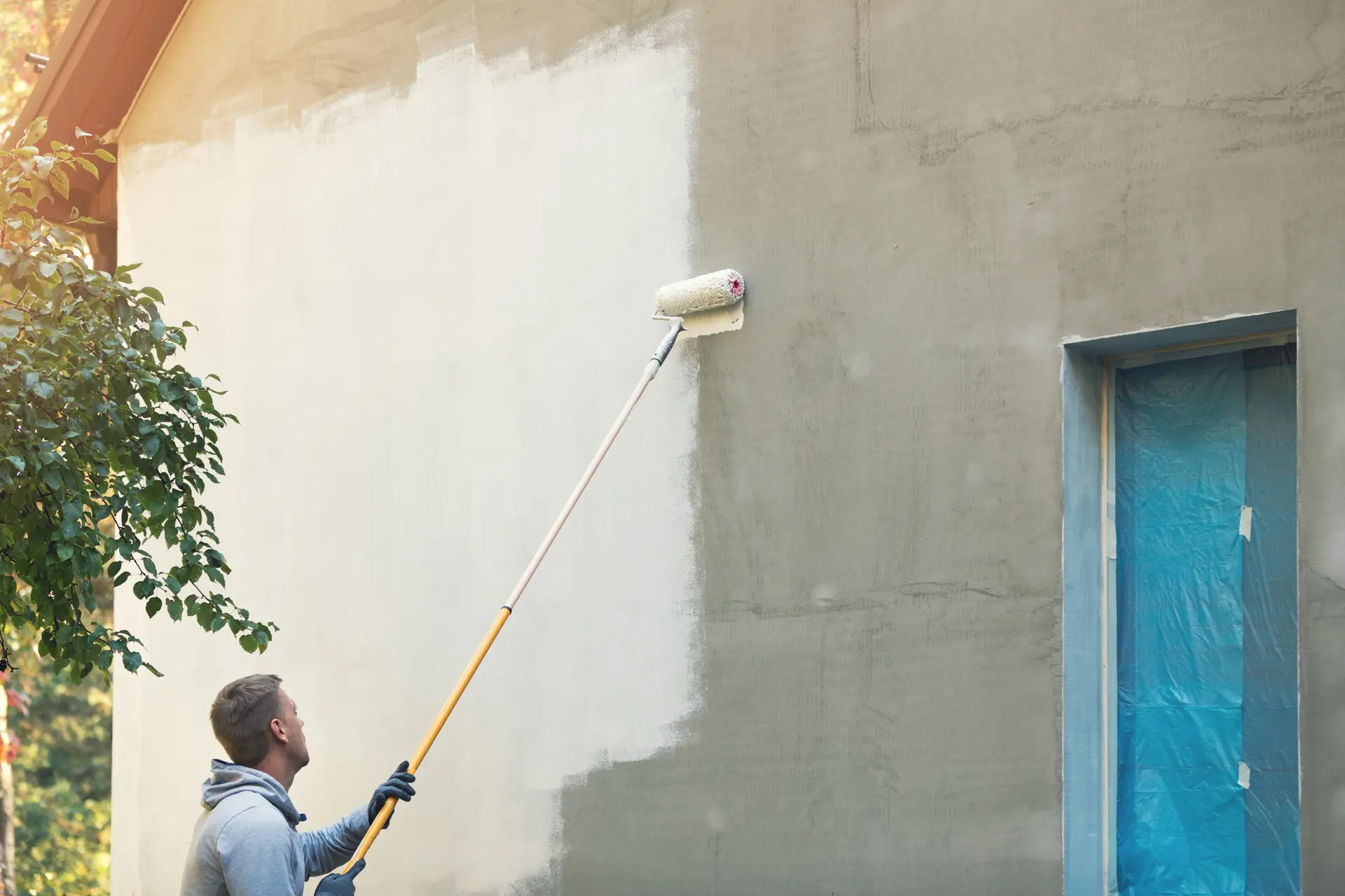 Pintor trabajando en una fachada en Valdemoro